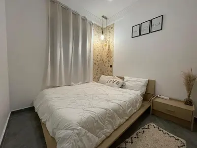 a small bedroom with a bed with white sheets at Gueliz Marrakech Apartment 5 Min City Center in Marrakech