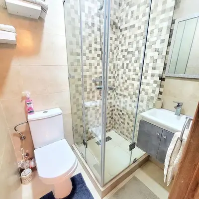 a bathroom with a toilet and a glass shower at Appartement haut standing plein centre gare in Marrakech