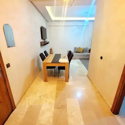 a dining room with a table and chairs and a couch at Appartement haut standing plein centre gare in Marrakech