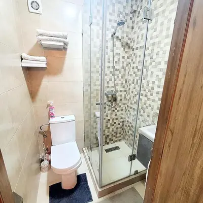 a bathroom with a toilet and a glass shower at Appartement haut standing plein centre gare in Marrakech