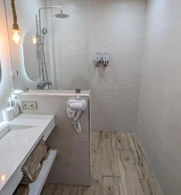 a white bathroom with a sink and a mirror at Apartement Panoramic View Majorelle Garden with Pool in Marrakech