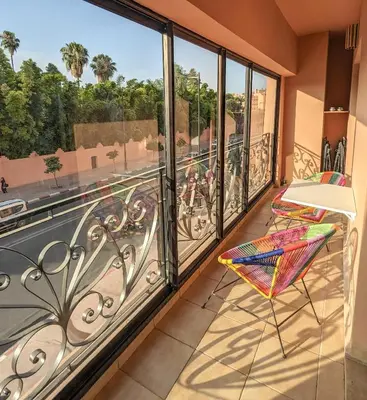 a balcony with a chair and a view of a street at Apartement Panoramic View Majorelle Garden with Pool in Marrakech