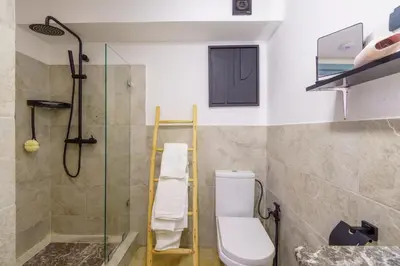 a bathroom with a shower and a toilet and a glass door at New ! Appartement DarSun - Terrasse - Fibre - Parking by Darlease in Marrakech