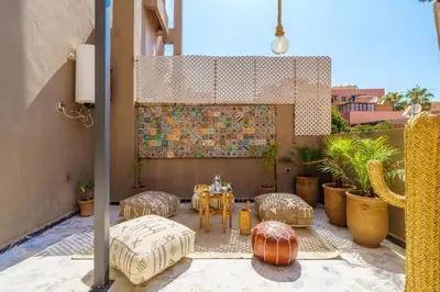 a patio with a table and chairs and a painting at New ! Appartement DarSun - Terrasse - Fibre - Parking by Darlease in Marrakech