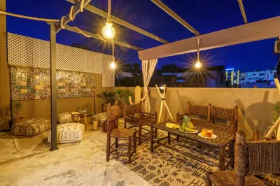 a patio with a table and chairs at night at New ! Appartement DarSun - Terrasse - Fibre - Parking by Darlease in Marrakech