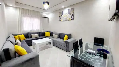 a living room with a blue couch and yellow pillows at Modern family apartment near airport in Marrakech