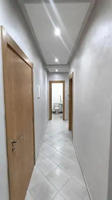 a hallway with a door and a tile floor at Modern family apartment near airport in Marrakech