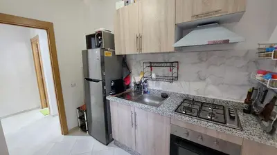a kitchen with a stainless steel refrigerator and a sink at Modern family apartment near airport in Marrakech