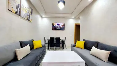 a living room with a blue couch and yellow pillows at Modern family apartment near airport in Marrakech