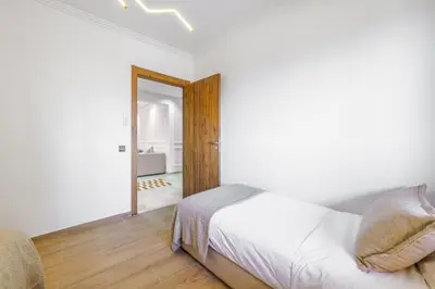 a white bedroom with a bed and a mirror at Elegant and cozy 3 bedrooms in Hivernage in Marrakech