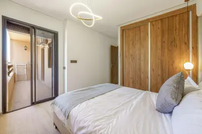 a bedroom with a white bed and a sliding glass door at Elegant and cozy 3 bedrooms in Hivernage in Marrakech