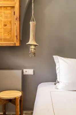 a bedroom with a bed and a table and a chandelier at Riad Macan Exclusive and Trendy Chich Breakfast incl in Marrakech