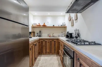 a kitchen with wooden cabinets and a stove at Riad Zatiah Exclusive and chic breakfast incl in Marrakech