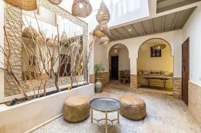 a living room with a table and two stools at Riad Zatiah Exclusive and chic breakfast incl in Marrakech