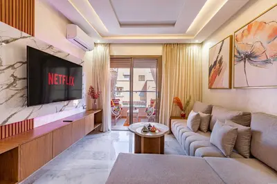 a living room with a couch and a tv at Magnifique appartement unique et central! in Marrakech