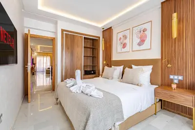 a bedroom with a large white bed and a television at Magnifique appartement unique et central! in Marrakech