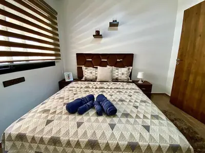 a bedroom with a bed with blue pillows on it at Appartement de luxe en face la gare à gueliz marrakech in Marrakech