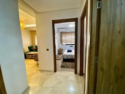 a hallway leading to a living room with a couch at Appartement de luxe en face la gare à gueliz marrakech in Marrakech