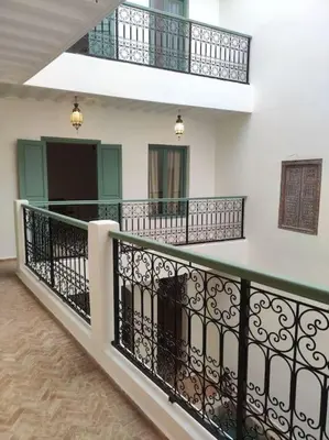 a balcony with a black railing and a staircase at Riad White Cactus in Marrakech