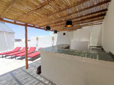 a patio with red chairs and a bar with a view at Riad White Cactus in Marrakech