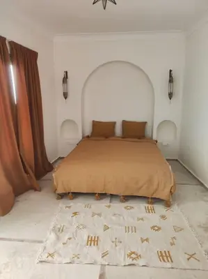 a bedroom with a large bed with a rug at Riad White Cactus in Marrakech
