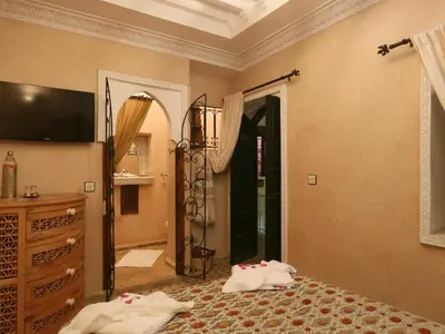 a bedroom with a bed and a dresser and a mirror at Riad El Bellar in Marrakech