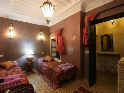 a hotel room with two beds and a mirror at Riad El Bellar in Marrakech
