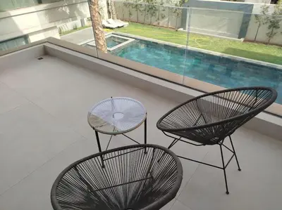 two chairs and a table next to a swimming pool at Villa Moderne au sein du Golf Amelkis in Marrakech