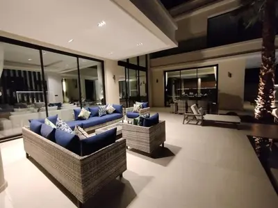 a large living room with blue couches and windows at Villa Moderne au sein du Golf Amelkis in Marrakech