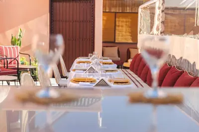 a long table with plates of food and wine glasses at Riad JW Yacout, vivez l'expérience Medina in Marrakech