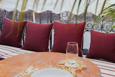 a table with purple pillows and a glass on it at Riad JW Yacout, vivez l'expérience Medina in Marrakech