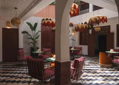 a restaurant with tables and chairs in a room at Riad JW Yacout, vivez l'expérience Medina in Marrakech