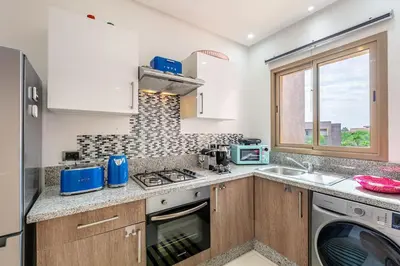 a kitchen with a sink and a stove top oven at Appartement luxe Prestige Opale Golf in Marrakech