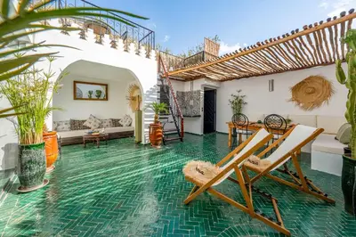 a living room with a green tile floor and chairs at Riad privatisé terrasses et matin gourmand in Marrakech