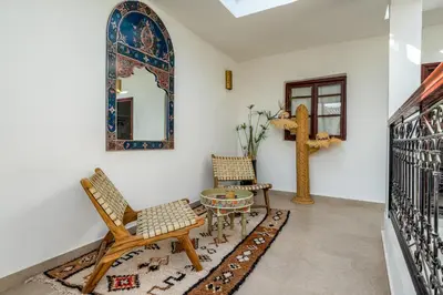 a room with chairs and a table and a mirror at Riad privatisé terrasses et matin gourmand in Marrakech