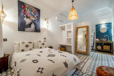 a bedroom with a bed with black and white sheets at Riad privatisé terrasses et matin gourmand in Marrakech
