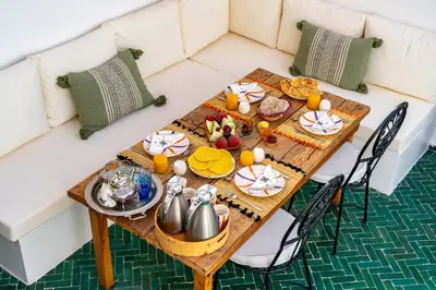 a table with food and tea on top of a couch at Riad privatisé terrasses et matin gourmand in Marrakech