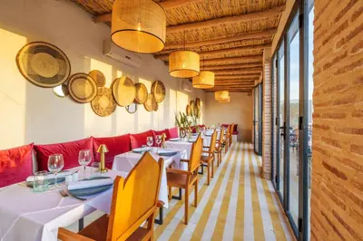 a row of tables in a restaurant with red seats at Suites & Spa - Riad XO in Marrakech