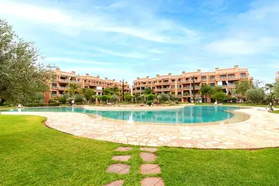 a swimming pool in the middle of a park with buildings at Rêve de MARRAKECH in Marrakech
