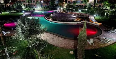 a large pool of water at night with lights at Rêve de MARRAKECH in Marrakech