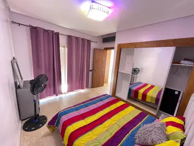a bedroom with a colorful bed and a mirror at Cosy appartement au Centre de Marrakech in Marrakech