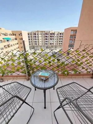 a patio with two chairs and a table on a balcony at Cosy appartement au Centre de Marrakech in Marrakech