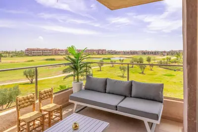 a living room with a couch and a large window at Vue Montagnes, Golf et Piscine, Luxe à Marrakech in Marrakech