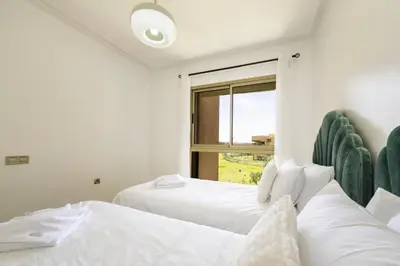 two white beds in a room with a window at Vue Montagnes, Golf et Piscine, Luxe à Marrakech in Marrakech
