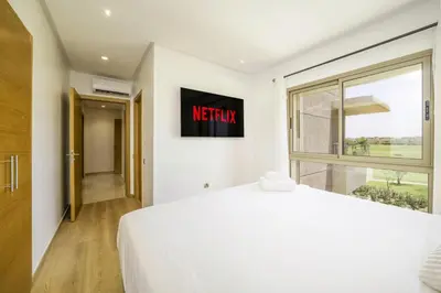 a bedroom with a white bed and a window at Vue Montagnes, Golf et Piscine, Luxe à Marrakech in Marrakech
