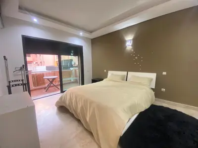 a bedroom with a large bed and a balcony at new and modern apartment in Marrakech