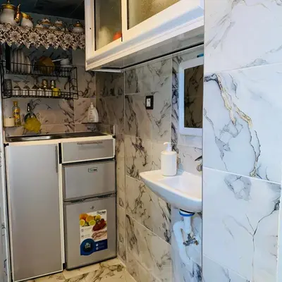 a bathroom with a sink and a white refrigerator at Dar Al-Karma in Marrakech