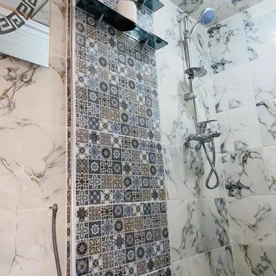 a bathroom with a shower with a tile wall at Dar Al-Karma in Marrakech