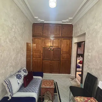 a living room with a couch and a wooden door at Dar Al-Karma in Marrakech