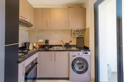a kitchen with a washing machine and a sink at Appartement NOVA Noria in Marrakech